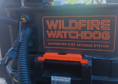 Wildfire Watchdog automated wildfire sprinkler system with roof and ground sprinklers, powered by ESP32/ESP8266 controllers, for remote monitoring in Central Oregon.