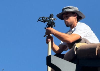 Technician installing wildfire detection and sprinkler system on roof.